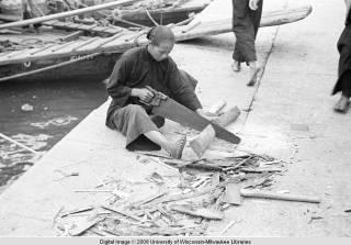 Hong Kong, woman cutting wood on a pier