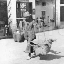 Man carrying baskets on shoulder pole