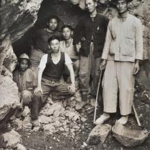 Chinese workers posing at the entrance to their mine