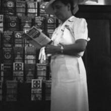 Hong Kong, American evacuee reading United Airlines brochure during World War II