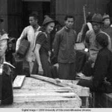 Hong Kong, an American evacuee with porters during World War II