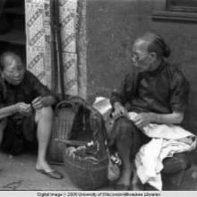 Hong Kong, two women sitting on side of street